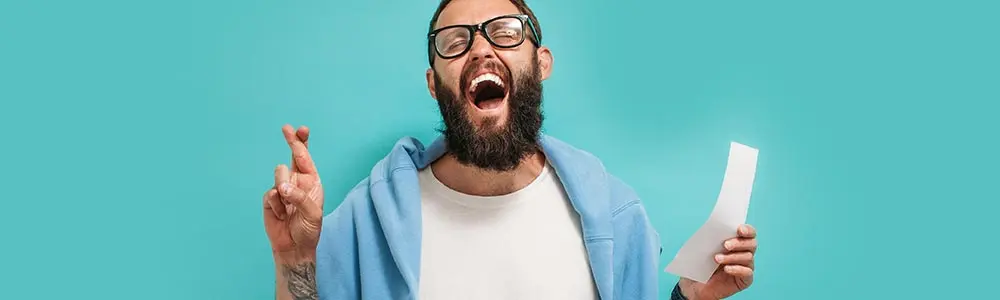 man with his fingers crossed hoping that his bet will pan out 